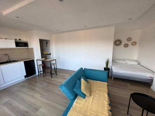 - un salon avec un canapé bleu et un lit dans l'établissement Studio cosy avec terrasse à deux pas de la gare, à Amiens