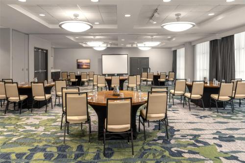 a conference room with tables and chairs and a whiteboard at Embassy Suites Fort Myers - Estero in Estero