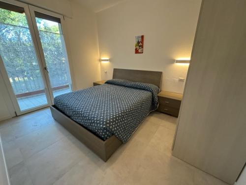Un dormitorio con una cama y una ventana grande. en App4rent - Villa Cristina 10 - RINNOVATO, en Lido di Jesolo
