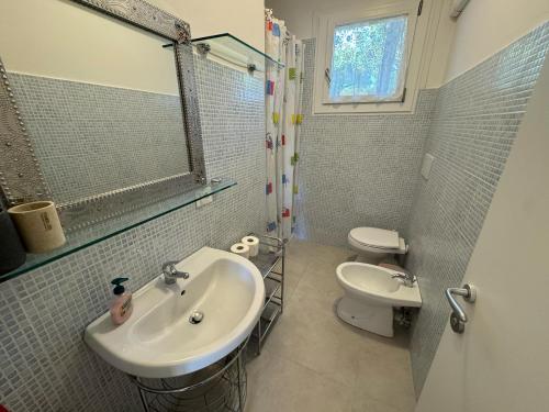 un baño con lavabo e inodoro en App4rent - Villa Cristina 10 - RINNOVATO, en Lido di Jesolo
