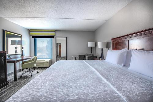 a hotel room with a large bed and a desk at Hampton Inn Newport News-Yorktown in Newport News