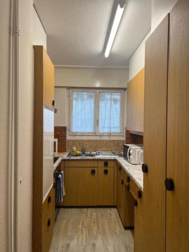 a large kitchen with a sink and a microwave at KARL Apartment in Interlaken
