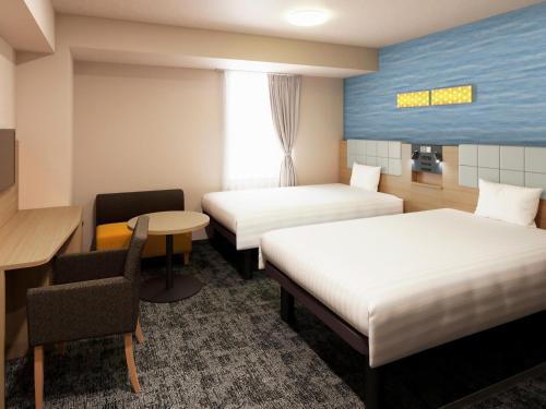 a hotel room with two beds and a desk at Comfort Hotel Tokyo Kiyosumi Shirakawa in Tokyo