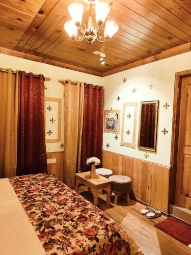a bedroom with a bed and a wooden ceiling at Flugafen B&B- A Peaceful home in Apple Orchards in Manāli