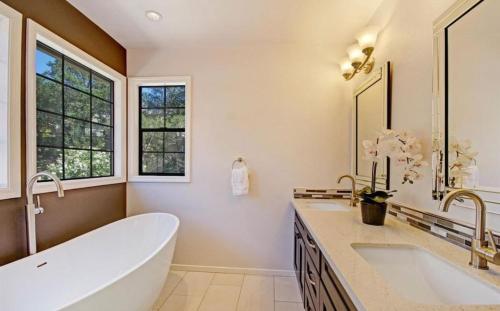a bathroom with a tub and two sinks and windows at Sonoma Hideaway 3BD 2,5 BATH, Beautiful Patio and Garden in Sonoma