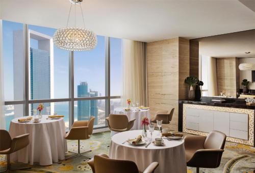 a restaurant with tables and chairs and a large window at Conrad Abu Dhabi Etihad Towers in Abu Dhabi