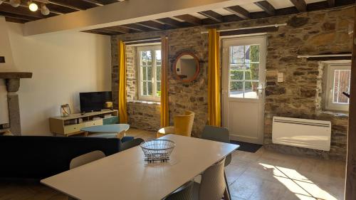un salon avec une table et des chaises dans l'établissement Maison Normande proche de la mer et des lieux touristiques, à Quettehou
