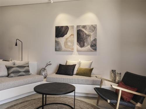 a living room with a couch and a table at Magma Resort Santorini, In The Unbound Collection By Hyatt in Vourvoulos