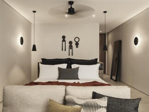 a bedroom with a large bed and a couch at Magma Resort Santorini, In The Unbound Collection By Hyatt in Vourvoulos