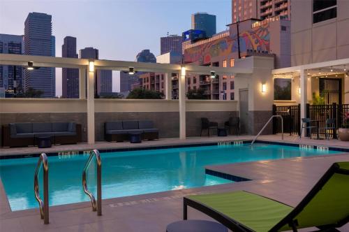 a large swimming pool with a city skyline in the background at Home2 Suites By Hilton Houston Downtown Convention Center in Houston