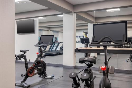 a gym with exercise bikes and a flat screen tv at Tru By Hilton Houston Downtown Convention Center in Houston