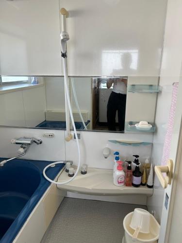 a person taking a picture of a bathroom at Rom's Inn in Wakimachi