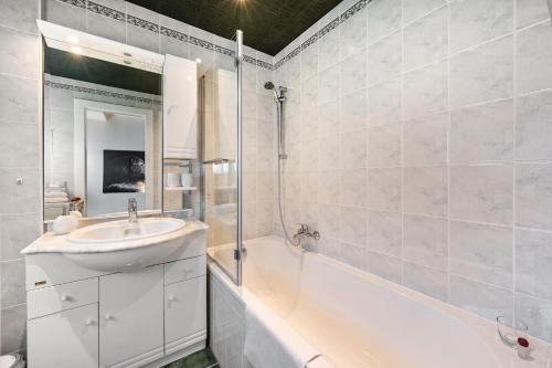 a white bathroom with a sink and a bath tub at Carpe Diem - Ferienwohnung in Görlitz