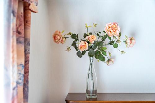 a vase filled with orange roses sitting on a table at Carpe Diem - Ferienwohnung in Görlitz