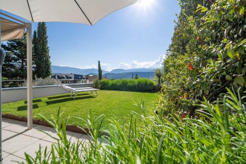 a garden with a bench and an umbrella at Helle und freundliche Unterkunft mit Terrasse für bis zu 4 Gäste in Caldaro