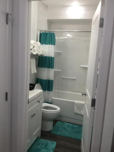 a bathroom with a tub and a toilet and a shower at Almost Heaven - Cozy 2BDRM APT near Heritage Park,Spruce Meadows & Banff-SW Calgary in Calgary