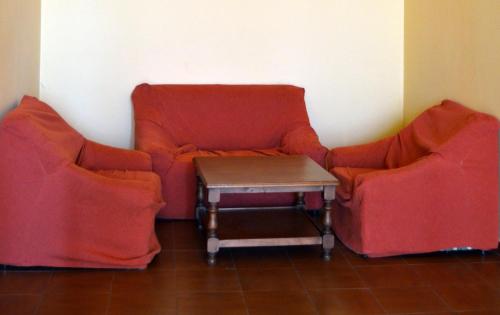 two orange chairs and a table in a room at Albergue Aurora Boreal in Casas del Monte