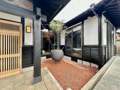 a large vase with a tree in the middle of a house at Spacious Traditional Japanese house by Restavio in Ozu