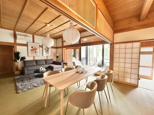 a living room with a dining table and chairs at Spacious Traditional Japanese house by Restavio in Ozu