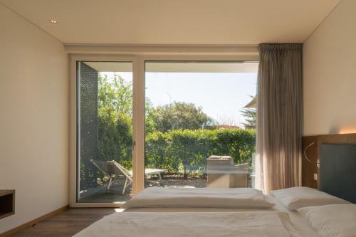 a bedroom with a bed and a sliding glass door at Appartement KroneLiving in Tirolo