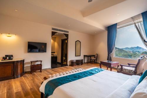 a bedroom with a large bed and a large window at Clarks Resort The Archi`s Castle, Ajmer in Ajmer