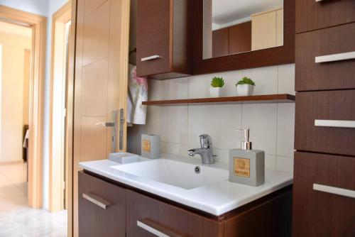una cocina con fregadero blanco y armarios de madera en Mailia Lagoon, en Vivari