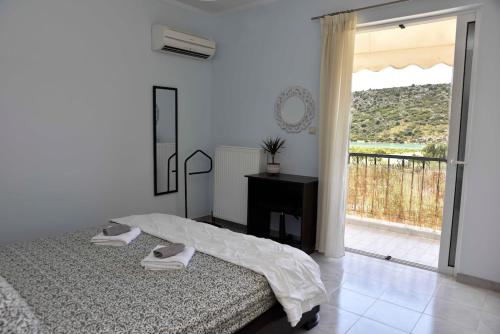 1 dormitorio con 1 cama y puerta a un balcón en Mailia Lagoon, en Vivari