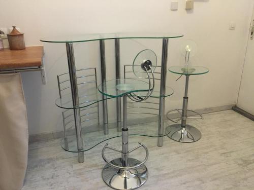 a couple of glass tables sitting on top of a floor at Chez Nahiko STUDIO Paris Massy Palaiseau in Palaiseau