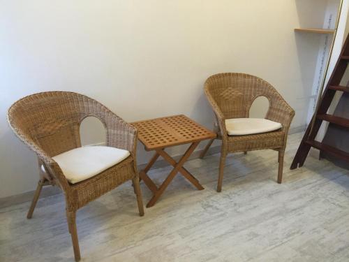 two wicker chairs and a table in a room at Chez Nahiko STUDIO Paris Massy Palaiseau in Palaiseau