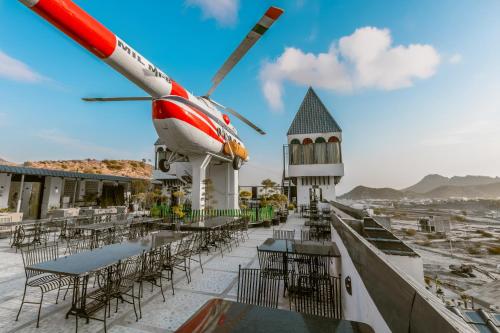 a helicopter sitting on top of a building with tables and chairs at Clarks Resort The Archi`s Castle, Ajmer in Ajmer