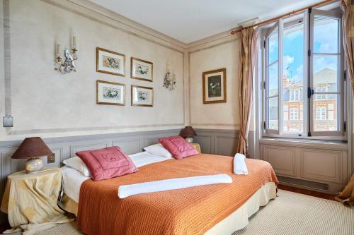 - une chambre avec un lit doté d'oreillers roses et d'une fenêtre dans l'établissement Luxurious 4 bedroom duplex, 200m from Place Morny, à Deauville