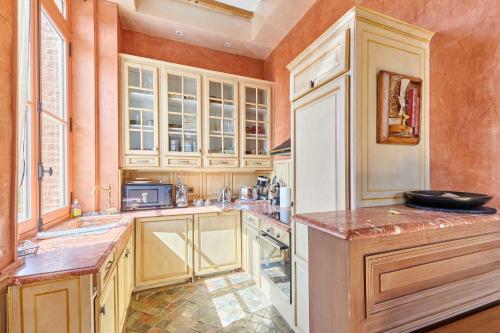 une grande cuisine avec des placards en bois et un comptoir dans l'établissement Luxurious 4 bedroom duplex, 200m from Place Morny, à Deauville