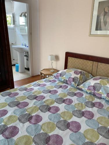 - une chambre avec un lit doté d'un couvre-lit coloré dans l'établissement L'Eden : à deux pas de la plage, à Arcachon