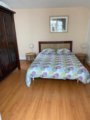 une chambre avec un lit et un parquet dans l'établissement L'Eden : à deux pas de la plage, à Arcachon