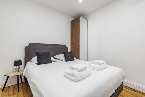 une chambre avec un lit blanc avec des serviettes dessus dans l'établissement CMG - LE MARAIS/SAINT ANTOINE, à Paris