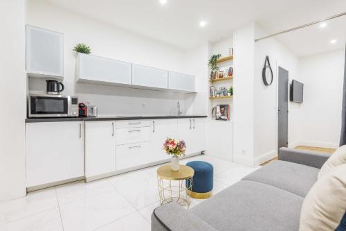 un salon avec un canapé et une cuisine dans l'établissement CMG - LE MARAIS/SAINT ANTOINE, à Paris