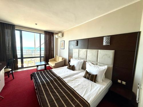 a hotel room with a bed and a large window at Hotel Rеgina - Golden Sands All Inclusive in Golden Sands