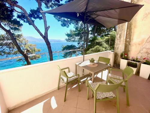 a patio with a table and chairs and an umbrella at Rondina House in Korčula