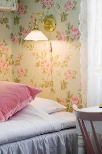 a bedroom with pink flowers on the wall at Strandvillan Hotell och Bed & Breakfast in Lysekil