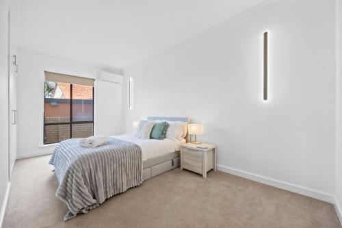 a white bedroom with a bed and a window at Waterfront Wonder in Dawesville in Dawesville
