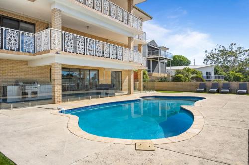 a swimming pool in front of a house at Waterfront Wonder in Dawesville in Dawesville
