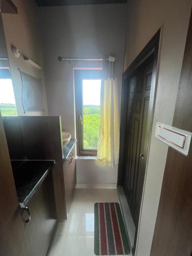 a bathroom with a window and a door with a rug at Hotel Aero One in Kurnool