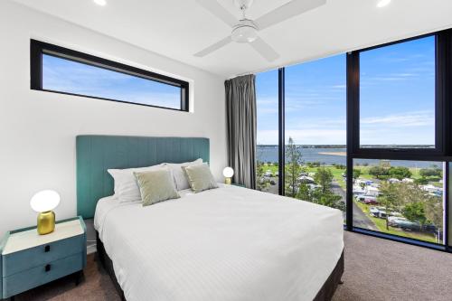 a bedroom with a large bed and large windows at Marine Quarter Apartments by CLLIX in Gold Coast