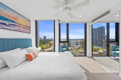 a bedroom with a large bed and large windows at Marine Quarter Apartments by CLLIX in Gold Coast