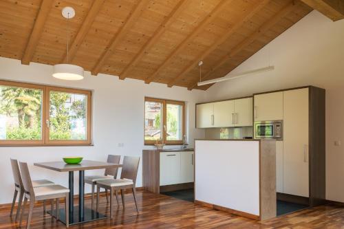a kitchen and dining room with a table and a refrigerator at Appartement KroneLiving in Tirolo