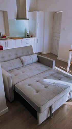 a large couch in a room with a kitchen at Casa de Bairros in Soajo