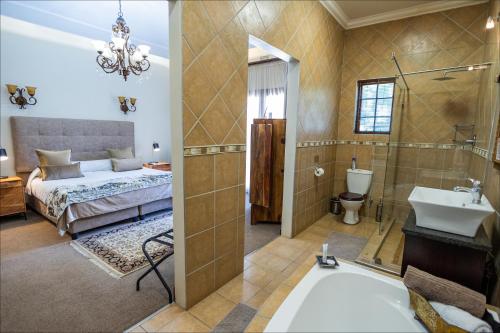 a bathroom with a bed and a sink and a tub at Scott's Manor Guesthouse Function and Conference Venue in Lichtenburg