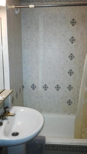 a bathroom with a sink and a tub and a white sink at Hotel El Libertador in Puerto Iguazú