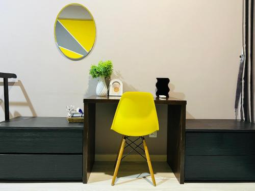 a yellow chair sitting next to a desk with a mirror at M Suite Homestay, Sutera Avenue Kota Kinabalu - Near Imago in Kota Kinabalu