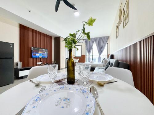 a dining room with a table with plates and a bottle at Alinea Suites by Moka in Shah Alam